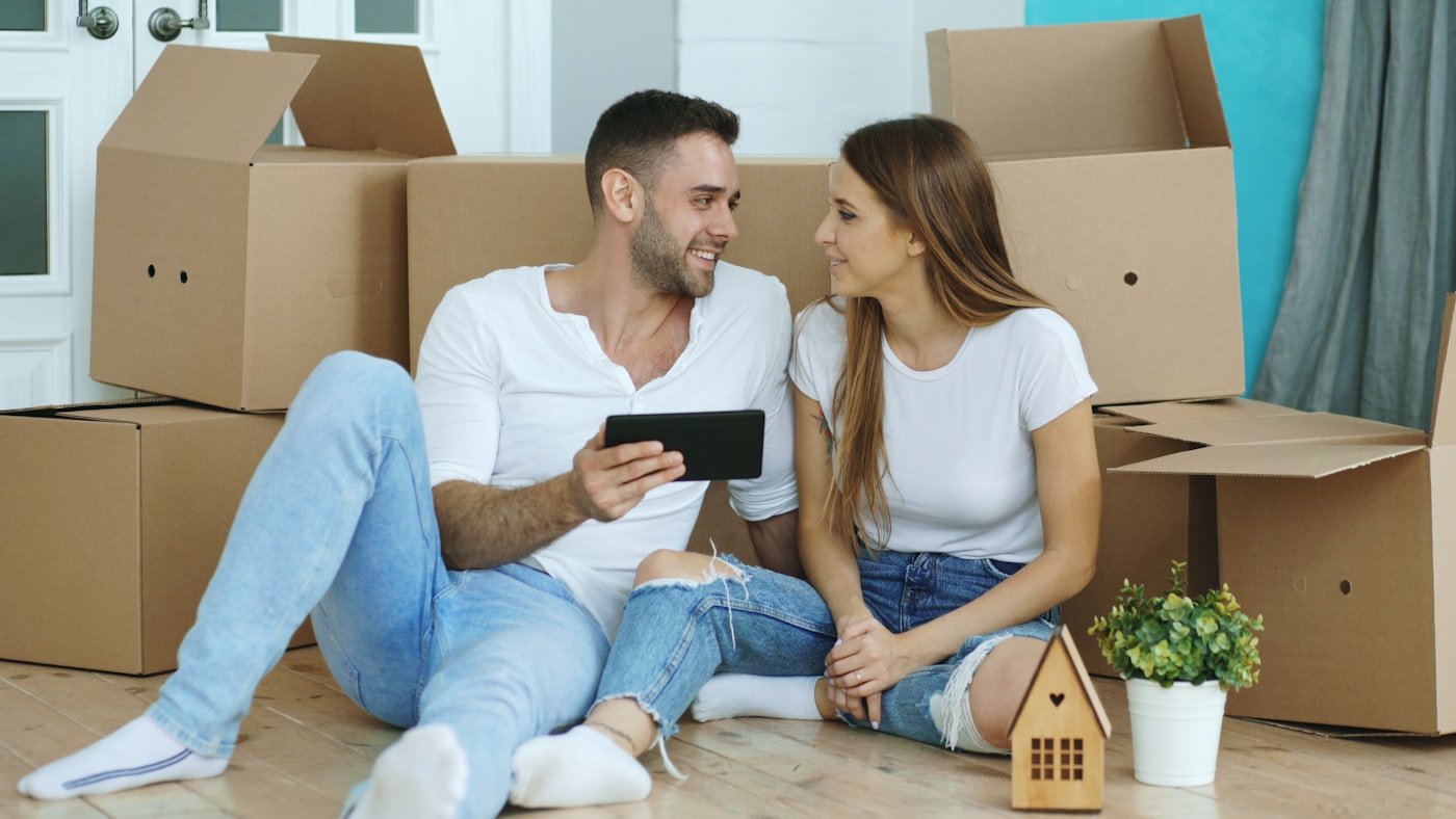 A happy couple settled into their new East Bay home, surrounded by moving boxes